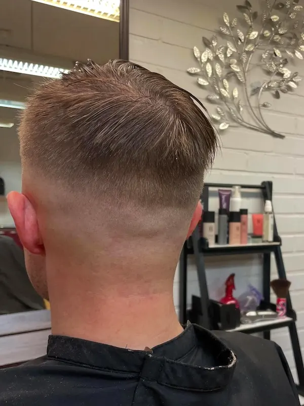 Miehen lyhyiden hiuksien hiustenleikkaus siistillä fade-häivytyksellä.