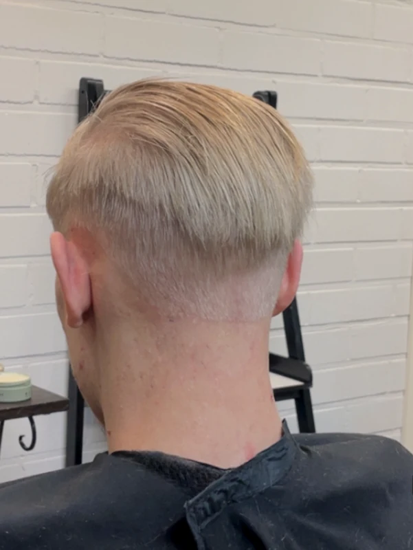 Miesten lyhyt slickback tyylinen hiusmalli sivujen häivytyksellä.